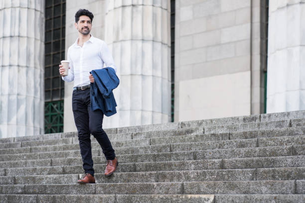 istock Businessman holding a cup of coffee on way to work. 1310109120