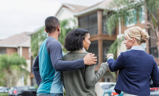 istock Young couple with real estate agent outside building 1310109535