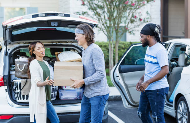istock Friends helping young woman move, unloading car 1310113658