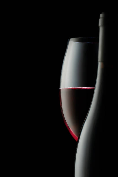 los contornos y curvas de una botella y una copa de vino tinto. un concepto para decorar una tienda de vinos o un restaurante - reflejo efecto de luz fotos fotografías e imágenes de stock