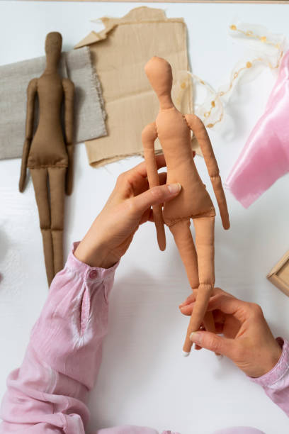 istock Woman designer making handmade dolls in the workshop. Hobby and passion. 1310117251