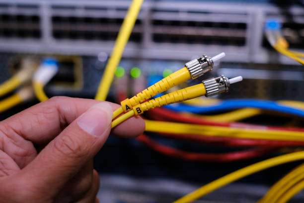 istock Close up fiber optic cable and blur network router switch on background in a technology data center room. ST-LC Patch Cord 1310117413