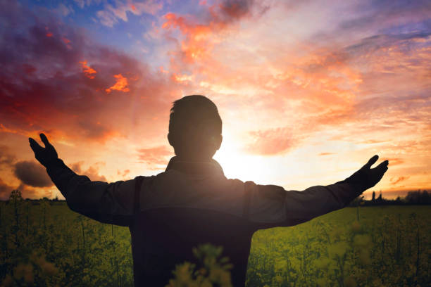 istock Easter concept: man raising his hands in worship on sunset background 1310118647