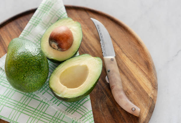 istock Close up of split Avocado on cutting board on marble table 1310120639