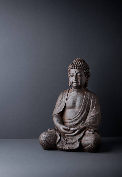 istock Meditating Buddha Statue on paper background. Copy space. 1310120744