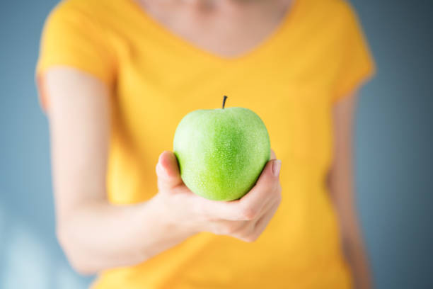 istock Woman holding green apple 1310123289