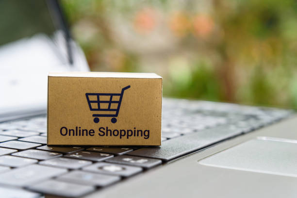 Paper carton with a shopping cart or trolley logo on a laptop keyboard Online shopping / ecommerce and delivery service concept market vendor photos stock pictures, royalty-free photos & images