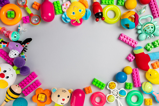 Bunch of baby toys on grey background. Flat lay concept.
