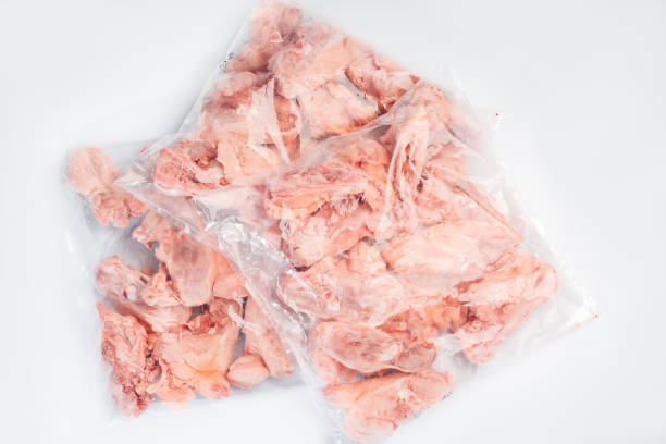 istock Raw meat box for supermarket, retail.Raw chicken backs in a package packed in a box for delivery on a white isolated background. 1310127348