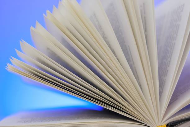 istock Reading books .Open book on a blue background. Close-up book pages.Learning and knowledge concept. 1310127867