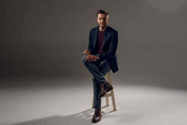 istock Handsome surgeon with needle holder and surgical knife weared casual suit in studio. Confident business man on dark background 1310129035