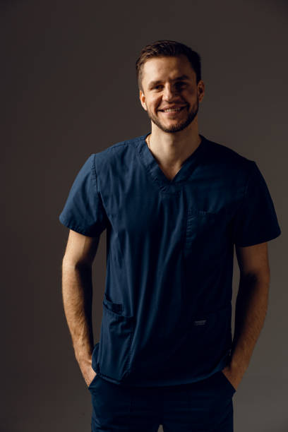 istock Surgeon weared in medical robe on dark background. Handsome doctor posing in studio 1310129132