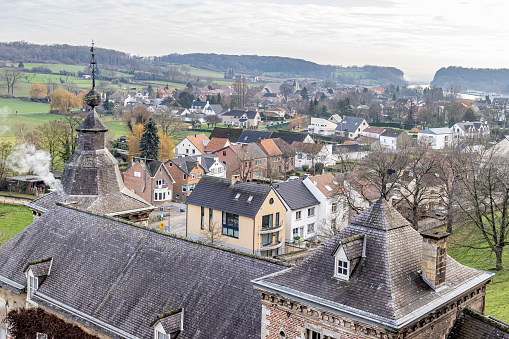 Aerial view of a small town among the Dutch countryside with its green meadows, bare trees, urban landscape, cloudy morning with a cloud covered sky, in South Limburg, the Netherlands