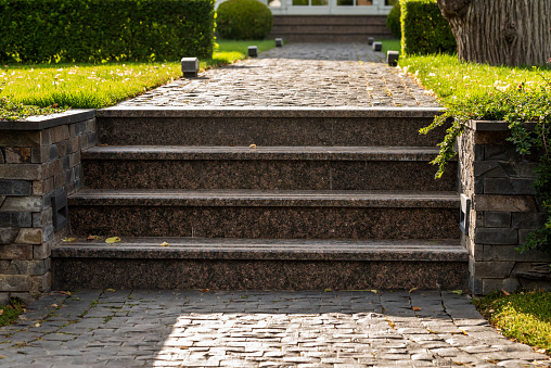 stone steps on the street near the green lawn exterior of a residential building