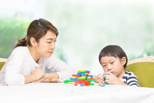 istock Happy mother watching her son play on the table 1310132234