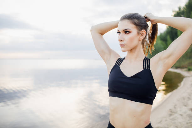 istock athletic girl with tank top doing a stretch on the beach 1310133409