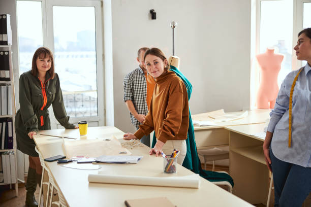 istock Two dress designers standing near table with tailoring tools 1310133445