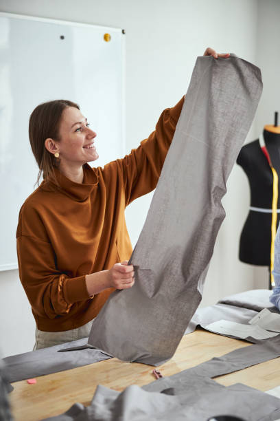 istock Female dressmaker raising fabric sheet in hands 1310133552