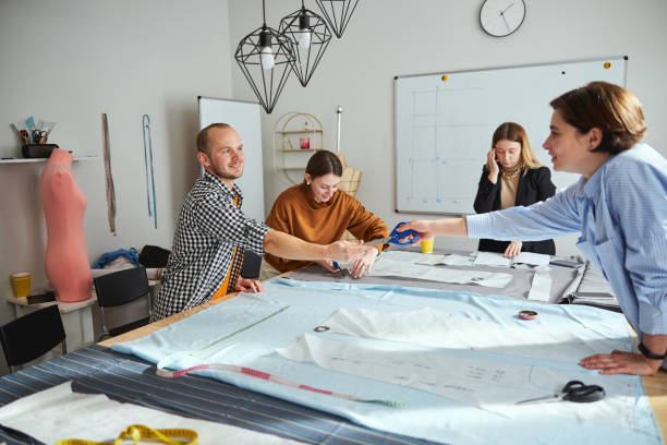 istock Professional designer is sharing scissors with woman 1310134179