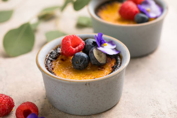 creme brulee. dessert alla crema alla vaniglia francese con zucchero caramellato e bacche, messa a fuoco selettiva. - brule foto e immagini stock