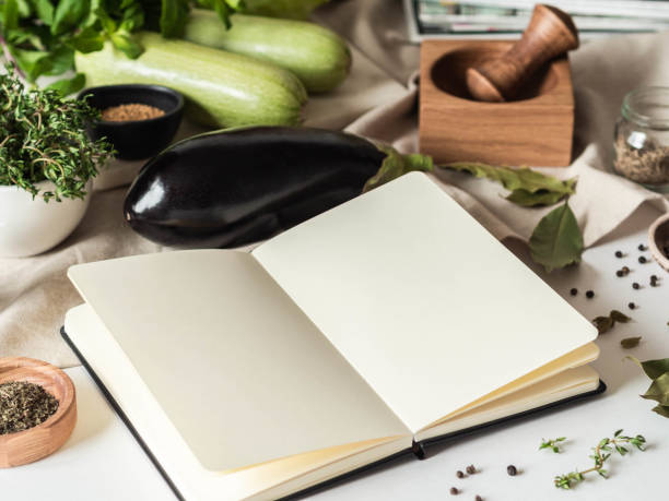 istock Open notebook for cooking recipes and various vegetarian ingredients on kitchen table 1310137593