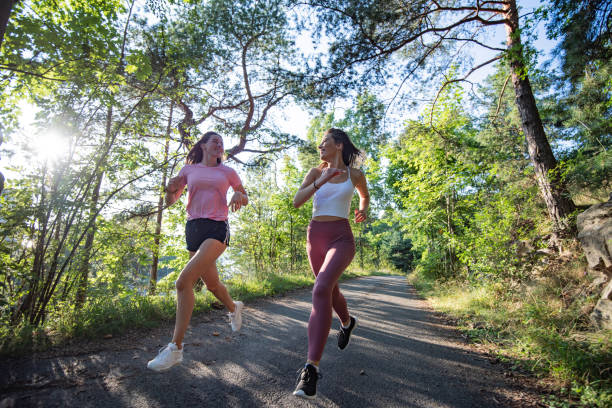 dos mujeres corriendo juntas en el parque. - family sport exercising jogging fotografías e imágenes de stock