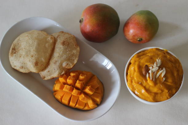 puri served with mango pulp locally known as aamras. mango pulp is made from lalbagh mango - lalbagh imagens e fotografias de stock