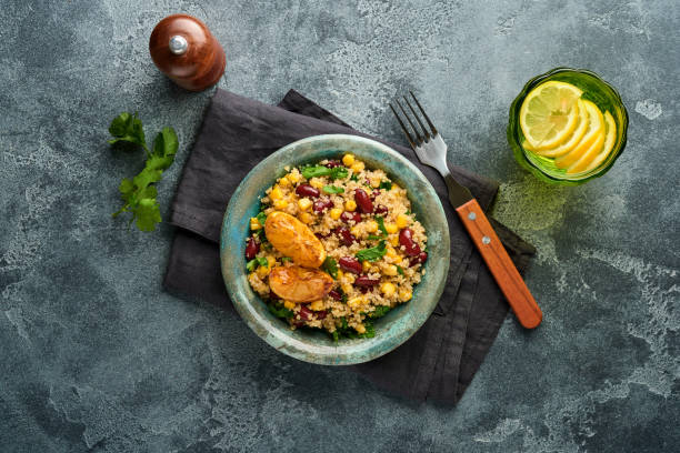 istock Mexican black bean corn quinoa salad with caramelized lemon in old vintage clay bowl on a dark gray concrete background. Traditional Mexican cuisine dish. Top view, mock up. 1310143139