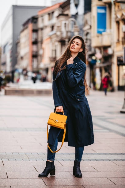istock Beautiful young woman wearing raincoat downtown 1310143489
