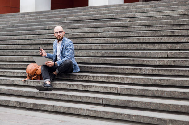 istock businessman with laptop works on the steps 1310144995