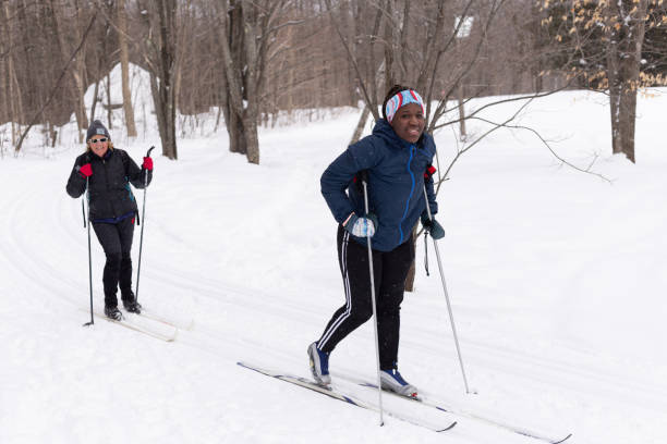 una adolescente y una mujer disfrutando de un día de esquí de fondo - nordic event fotografías e imágenes de stock