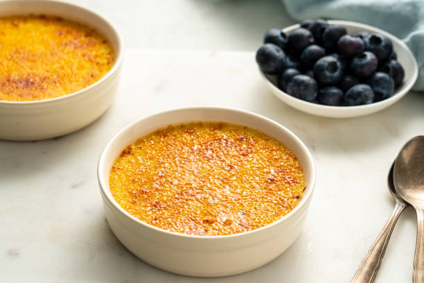 creme brulee em ramekin. feche a sobremesa de creme de baunilha francês. creme queimado. crema espanhol catalana - custard creme brulee french cuisine crema catalana - fotografias e filmes do acervo