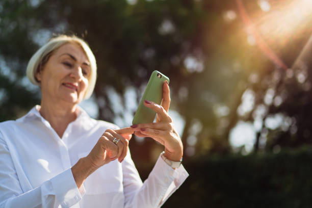 istock Woman using on mobile phone while resting at the park 1310147216