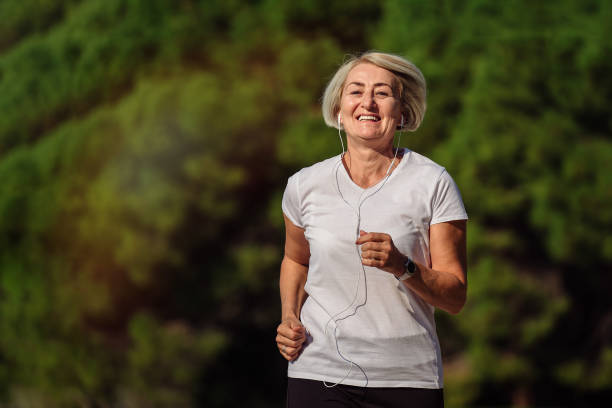 istock Senior woman jogging at sunrise 1310147456
