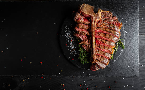istock Sliced Steak T-bone or aged wagyu porterhouse grilled beef steak Medium rare on stone table. menu recipe place for text, top view 1310148044