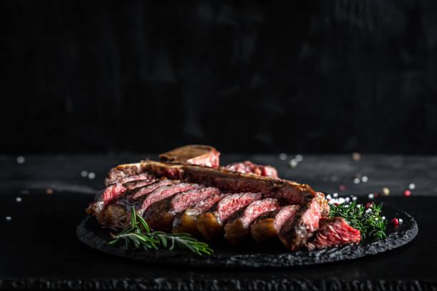 traditional american barbecue dry aged steak sliced. porterhouse steak sliced as top view on a slate board. banner, catering menu recipe place for text - red meat meat dish grilled rare imagens e fotografias de stock