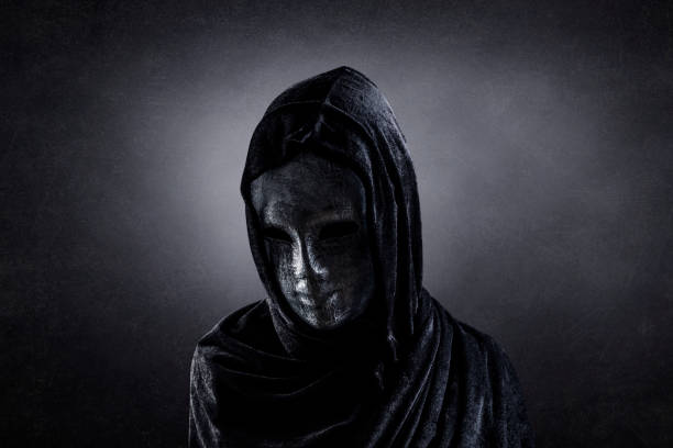 istock Scary figure with hooded cape in the dark 1310148907