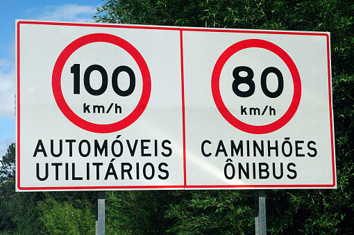 Highway speed limit sign indicating the maximum speed for automobiles 100 km/h, and 80 km/h for trucks, and buses on a highway, State of São Paulo, Brazil.