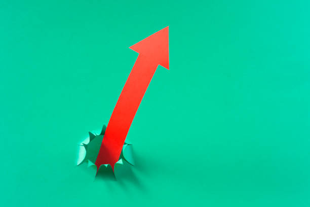 Finance concept with red paper arrows on green colored background