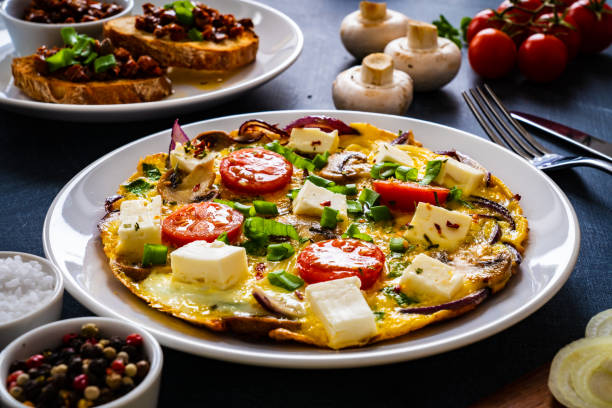 istock Continental breakfast -  scrambled eggs with feta cheese and fresh vegetables on wooden table 1310161581
