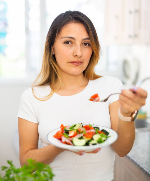 istock Female eating healthy salad with fresh vegetable 1310162666