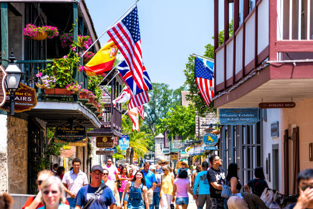 persone che fanno shopping nella città della florida st george street negozia negozi e ristoranti nella città vecchia con bandiere americane e internazionali - st george flag architecture famous place foto e immagini stock