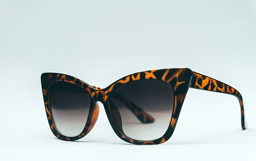 Dark sunglasses with tinted lenses and leopard-print frames. Summer fashion and style