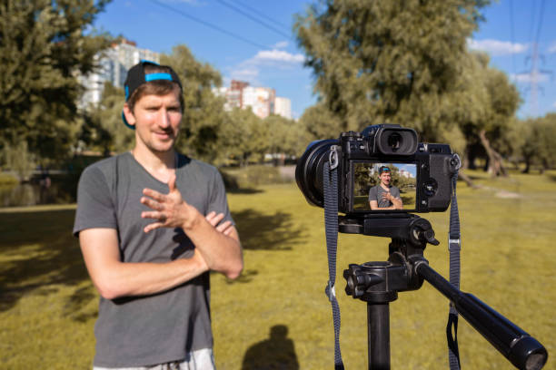 istock A blogger records a video tutorial in the park on camera. blogging concept. Vlog, remote work 1310167475