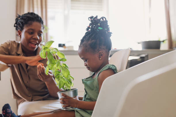 istock Cute Girl Curiously Looking the Basil While Mother is Teaching Her About Plants 1310168686