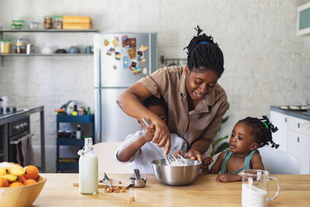 istock Happy Mother, Daughter and Son Preparing Whipped Cream in a Kitchen 1310168701