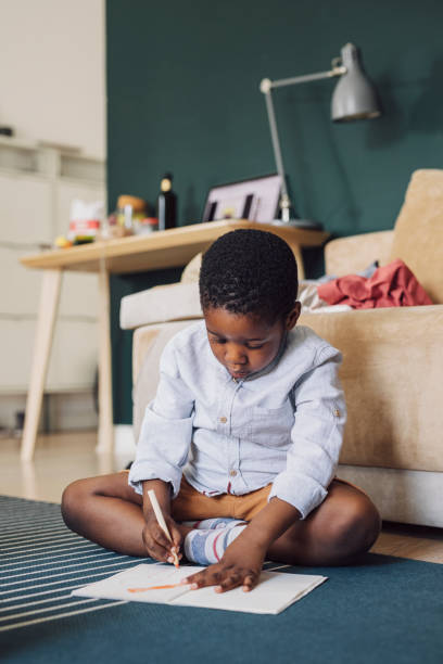 istock Young Boy Using Colour Pencils Drawing on the Floor 1310168707
