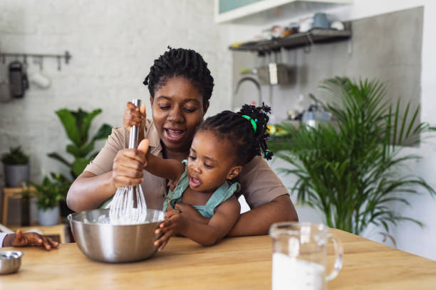 istock Happy Mother and Daughter Preparing Whipped Cream in a Kitchen 1310168713