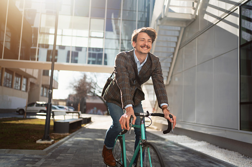 Young Caucasian businessman riding his bike on the way to work.