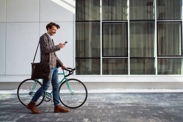 istock Side view of a young man going to office by bicycle and texting on phone 1310168894